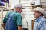 two older gentleman talking at a salebarn 